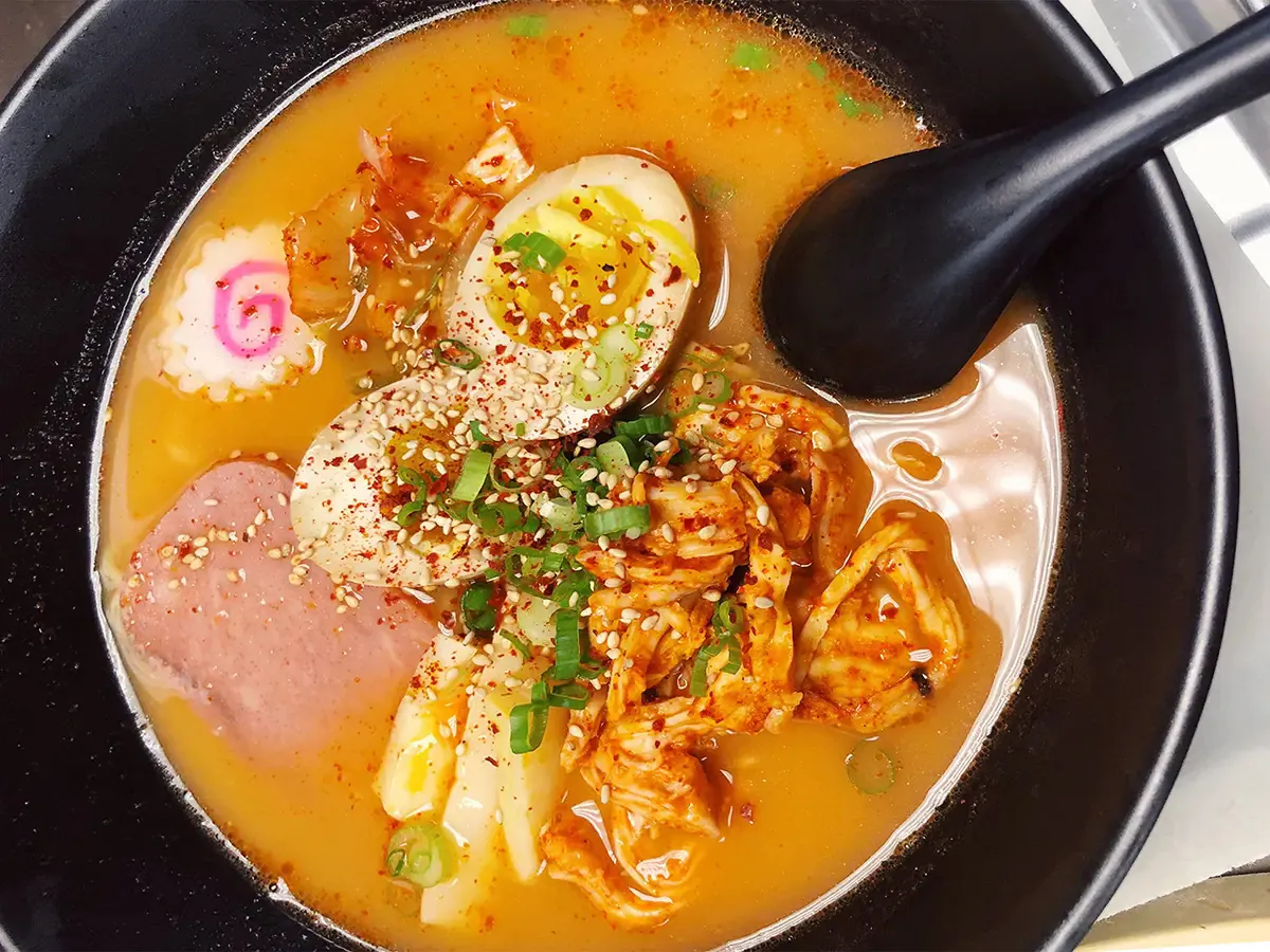 Ramen bowl with egg, meat, and garnished with sesame seeds and scallions at Pokéloha, a Asian Fusion Restaurant in Woonsocket